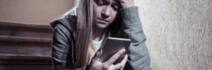 sad young girl looking at phone