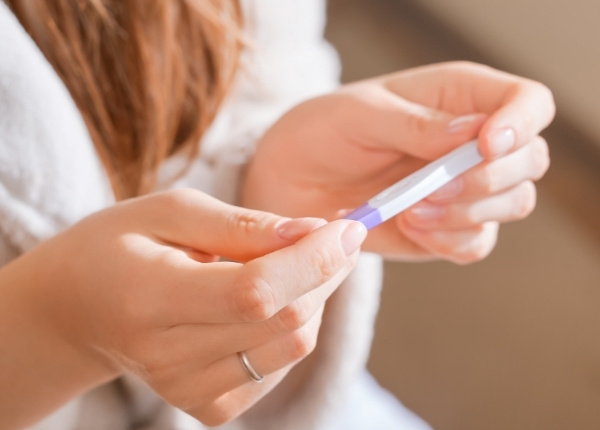perinatal woman holding pregnancy test in hands