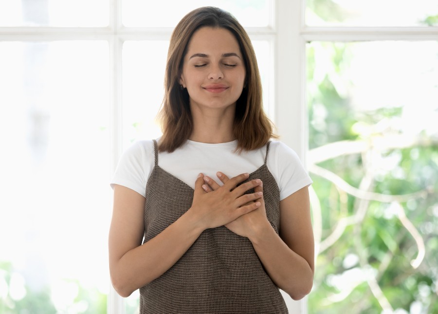 woman with hands on heart practicing gratitude