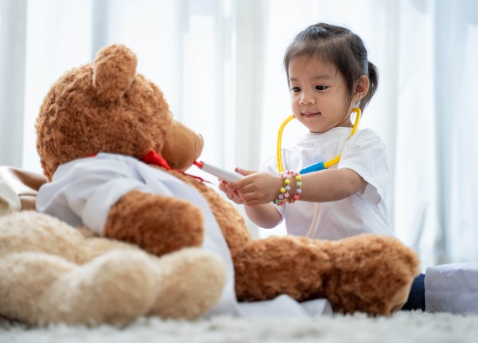 young girl playing doctor; pretend play; play therapy